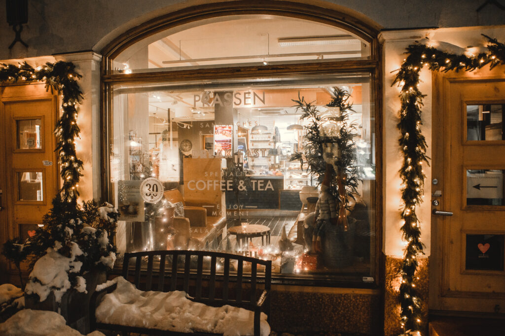 Cafe Prassen kuvattu ulkoapäin. Lunta ja jouluvaloja.