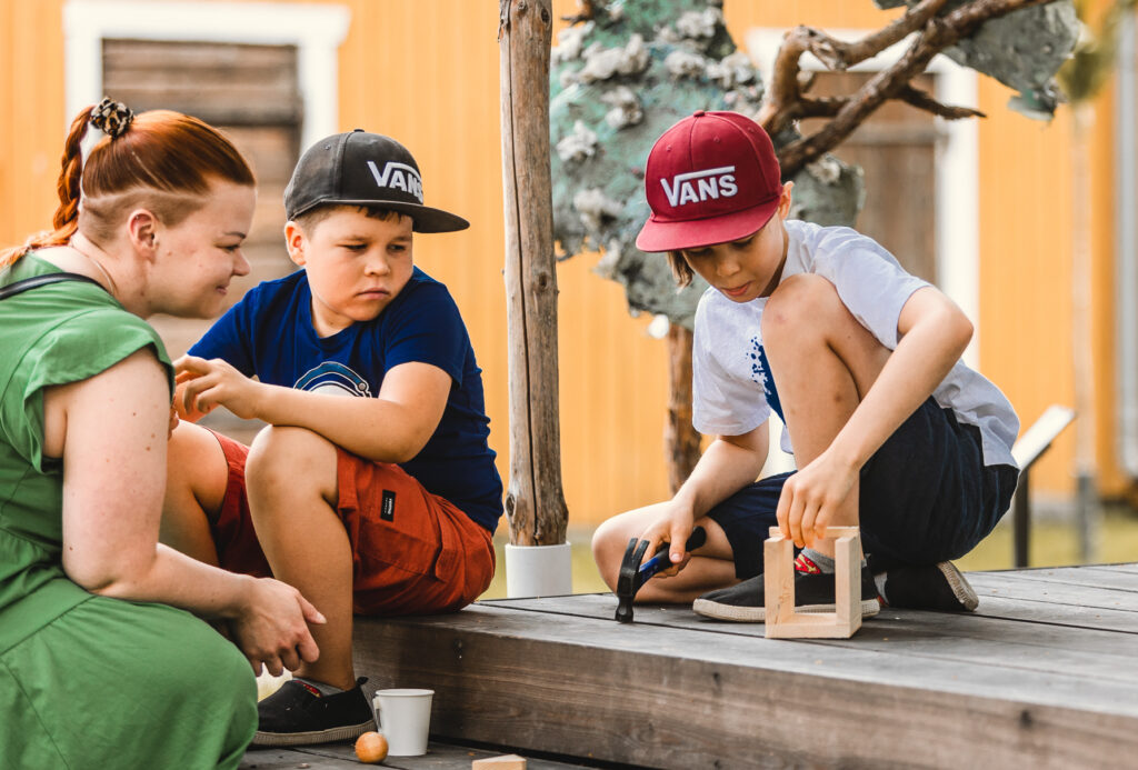 Lapsia nikkaroimassa puusta
