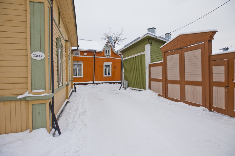 A snowy street in Old Rauma surrounded by colorful houses.