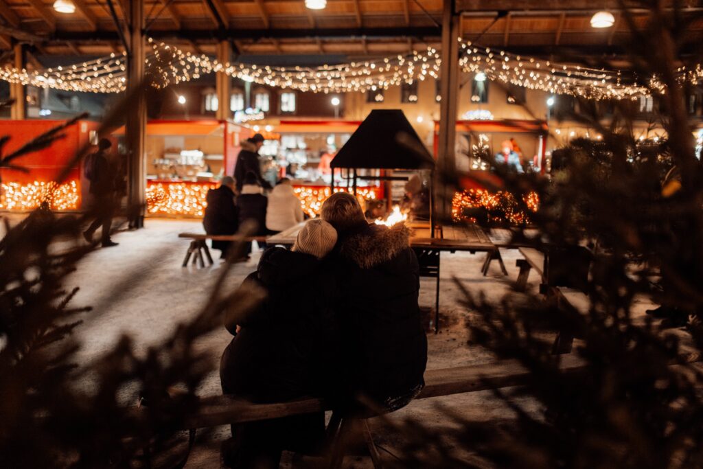 Two people sitting in Rauma's Christmas market.