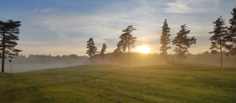 Golfkenttä auringonlaskun aikaan.