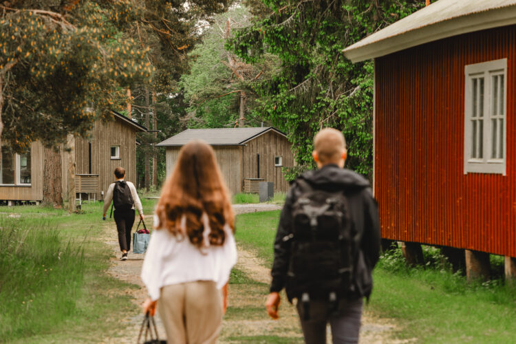People walking towards cabins in Kuuskajaskari island.