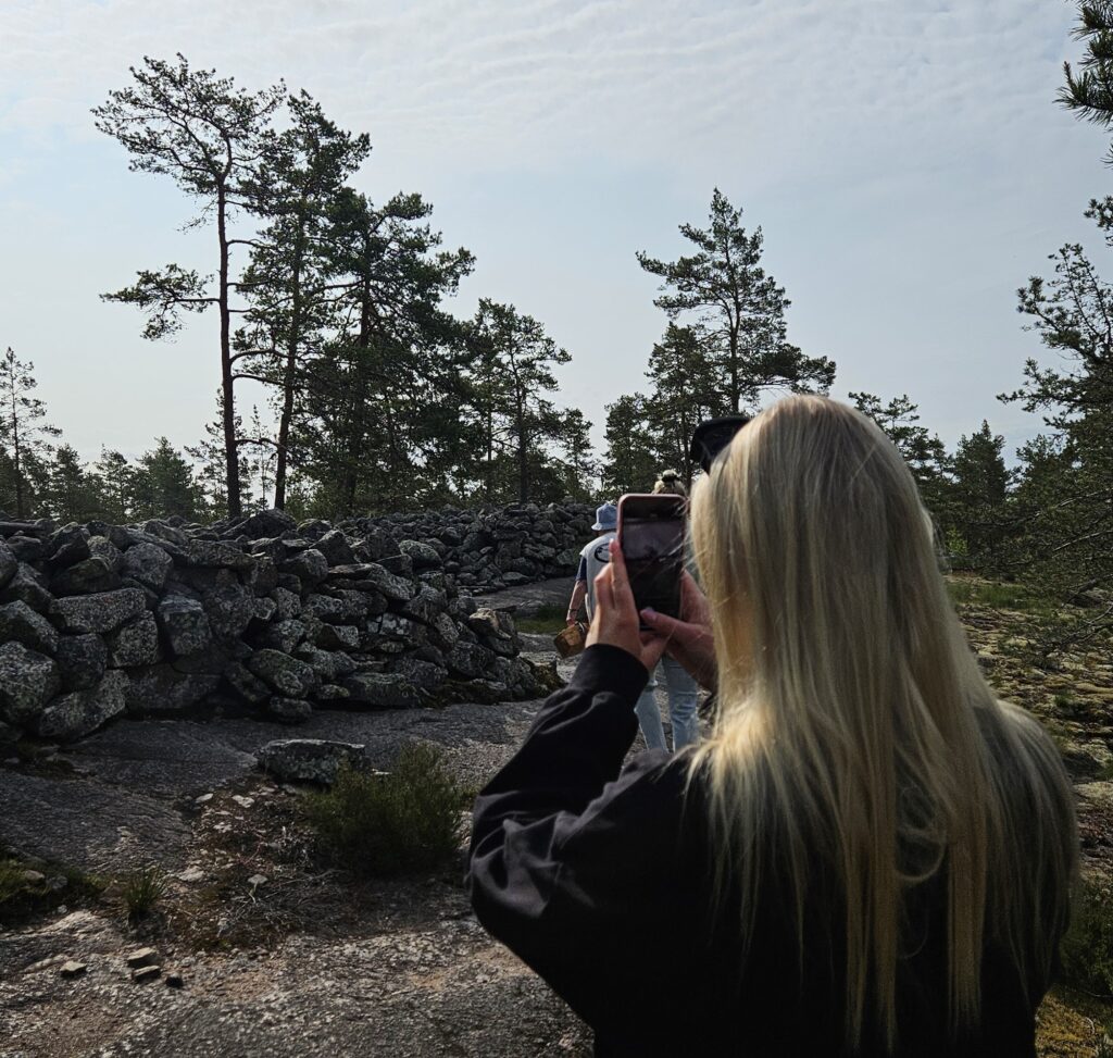 Ihminen ottamassa valokuvaa Sammallahdenmäellä.