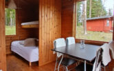 Karttu cottage from the inside. Bunk beds and a dining set. 