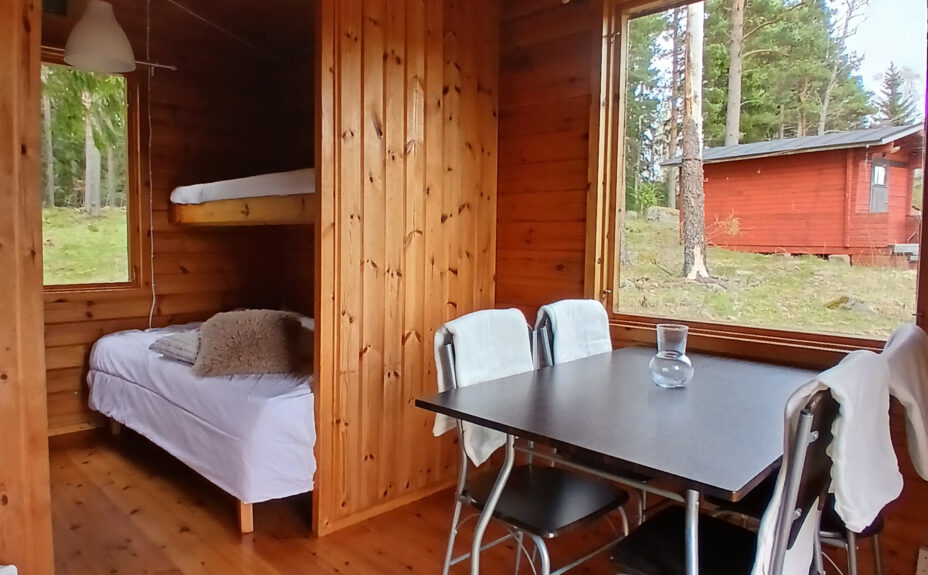 Karttu cottage from the inside. Bunk beds and a dining set. 