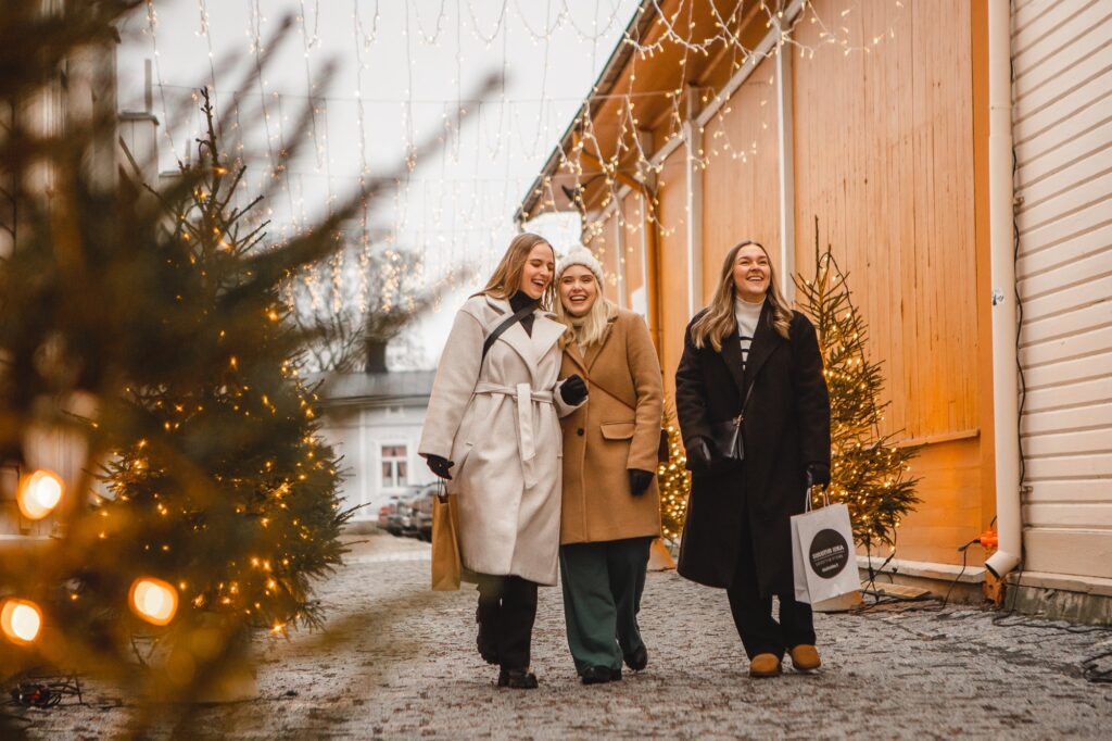 Ihmisiä kävelemässä Vähäraastuvankadun kuusikujalla jouluna.