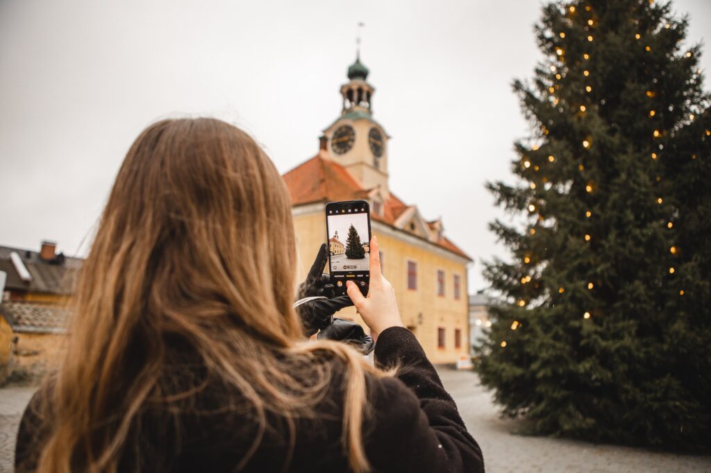 A woman taking a photo of the Christmas tree in Rauma Market Square.