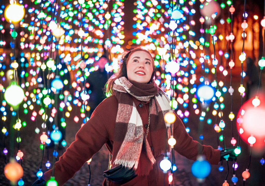 Ihminen roikkuvien valoköynnösten keskellä.